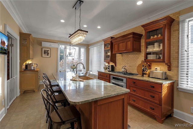 kitchen featuring stainless steel appliances, plenty of natural light, a sink, and a kitchen bar