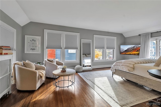 bedroom with lofted ceiling, baseboards, and dark wood finished floors