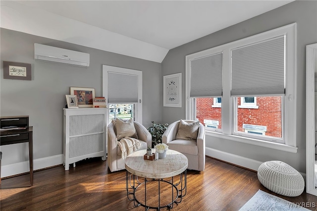 living area with a wall mounted AC, wood finished floors, and baseboards