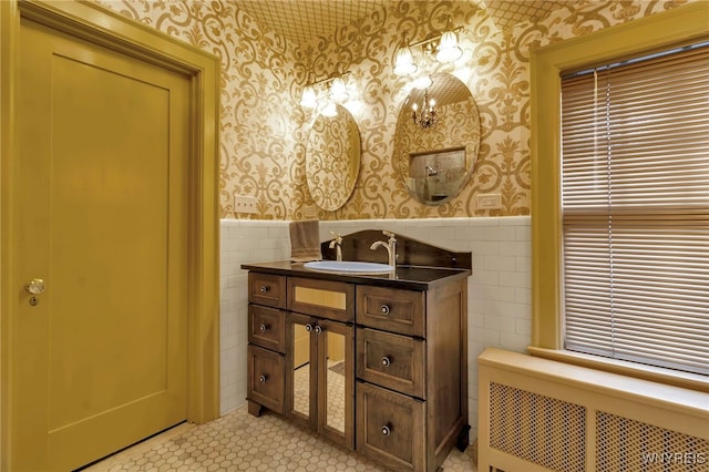 bathroom with wainscoting, tile walls, radiator heating unit, and wallpapered walls