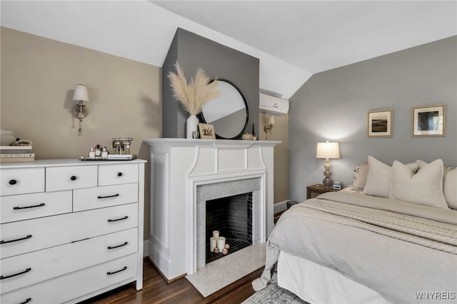 bedroom with lofted ceiling, a wall mounted AC, a fireplace, and dark wood-style floors