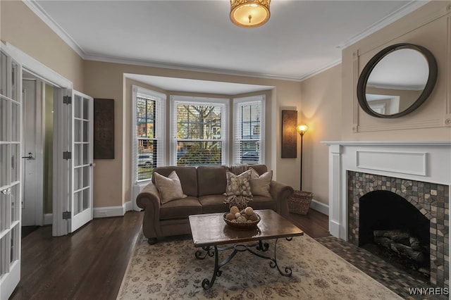 living room featuring dark wood-style floors, a fireplace, baseboards, and crown molding