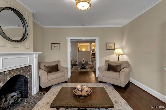 living room with baseboards, a tiled fireplace, wood finished floors, and crown molding