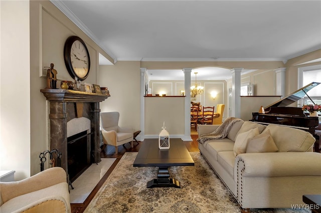 living area with a fireplace with flush hearth, ornamental molding, wood finished floors, and ornate columns