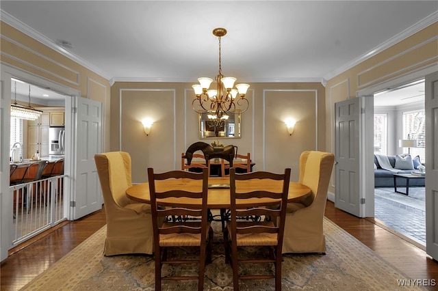 dining room with crown molding, wood finished floors, and a decorative wall