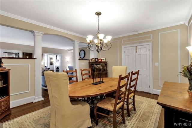 dining room with decorative columns, arched walkways, light wood-style flooring, and crown molding