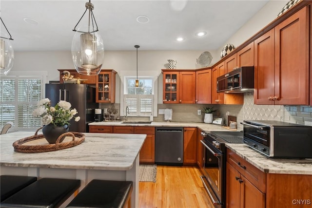 kitchen with glass insert cabinets, a toaster, appliances with stainless steel finishes, and a sink