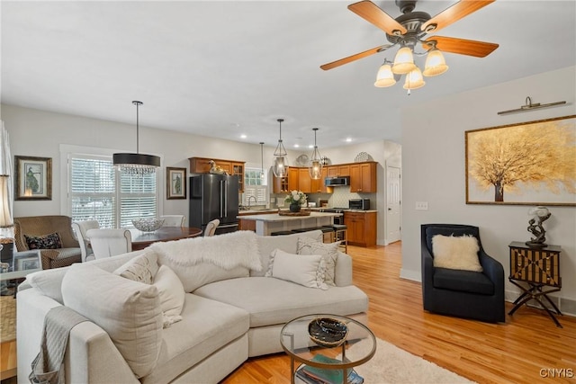 living room with ceiling fan, recessed lighting, baseboards, and light wood-style floors