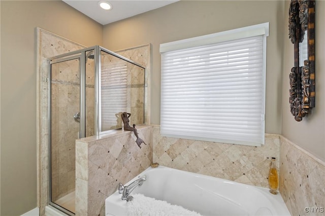 bathroom with a wealth of natural light, a shower stall, and a bath