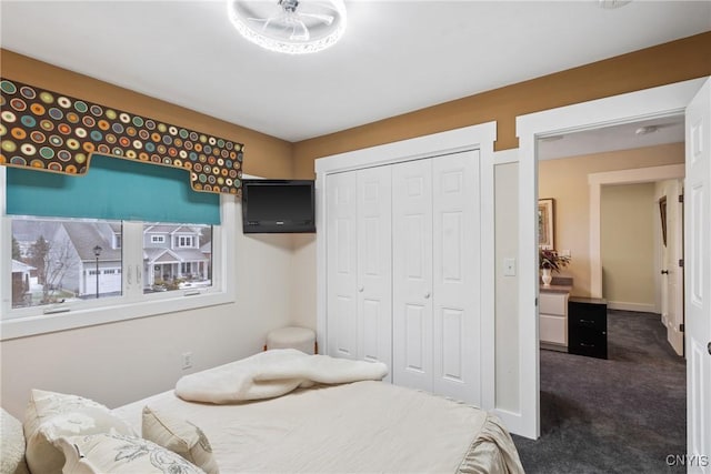 carpeted bedroom with baseboards and a closet