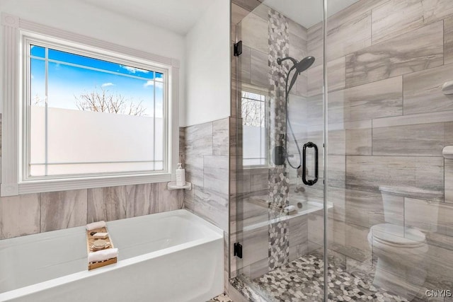 bathroom featuring a stall shower, a wealth of natural light, and a garden tub