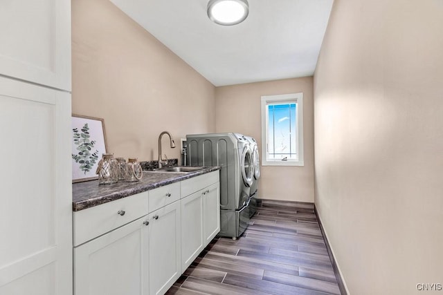 laundry room with cabinet space, dark wood-type flooring, a sink, independent washer and dryer, and baseboards