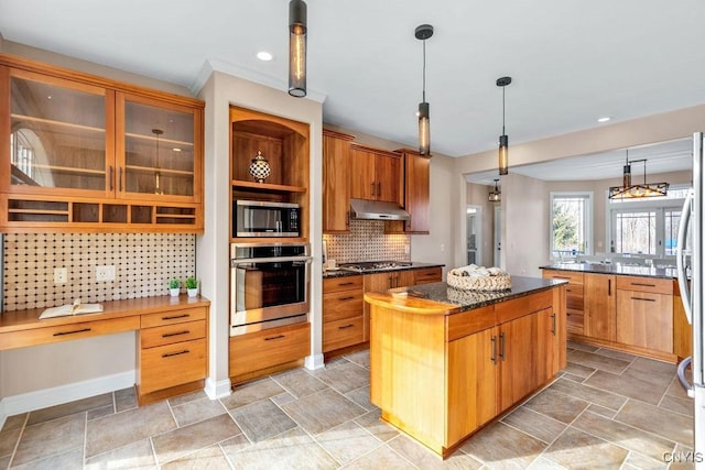 kitchen featuring decorative backsplash, appliances with stainless steel finishes, a center island, hanging light fixtures, and under cabinet range hood