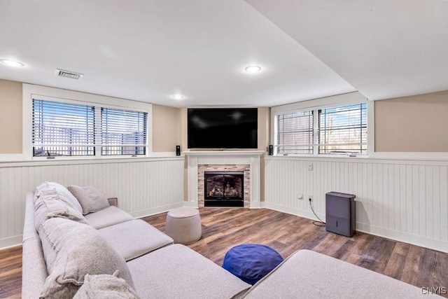 living area with a healthy amount of sunlight, visible vents, and wood finished floors