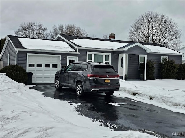 ranch-style home featuring an attached garage and a chimney