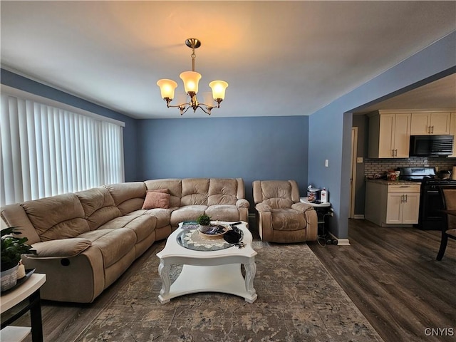 living area featuring baseboards, dark wood-style flooring, and an inviting chandelier