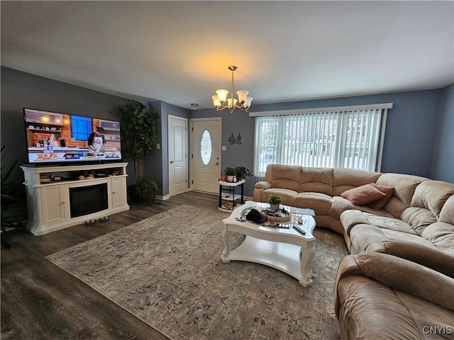 living area featuring dark wood-style floors, a fireplace, and a chandelier