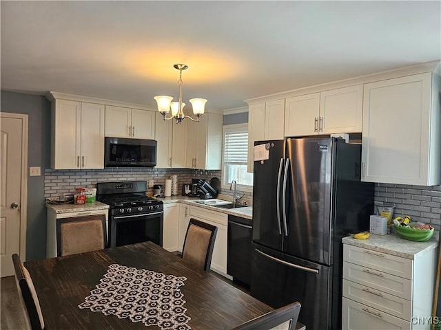 kitchen featuring decorative backsplash, a sink, black appliances, and an inviting chandelier