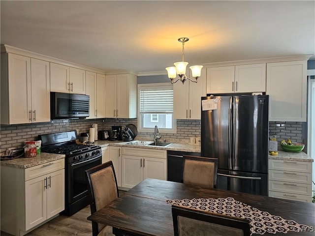 kitchen with decorative backsplash, white cabinets, and black appliances