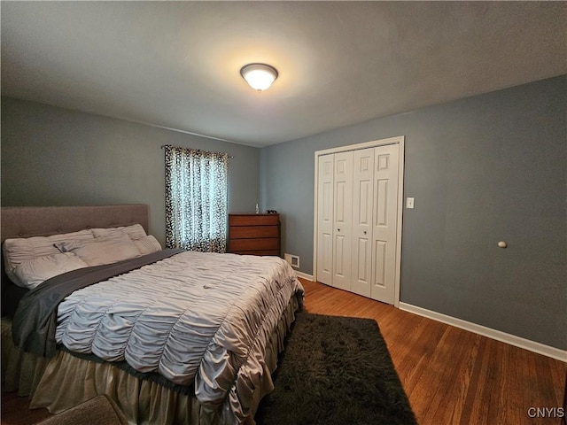 bedroom featuring a closet, wood finished floors, and baseboards