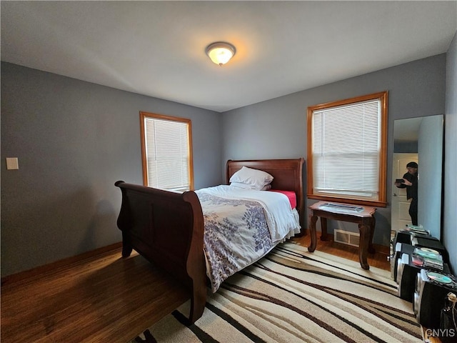 bedroom with baseboards and wood finished floors