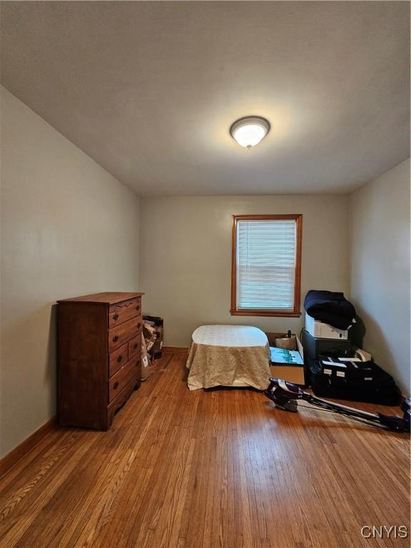 bedroom featuring wood finished floors and baseboards