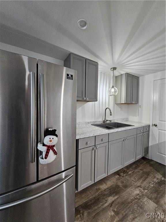 kitchen featuring gray cabinetry, a sink, and freestanding refrigerator