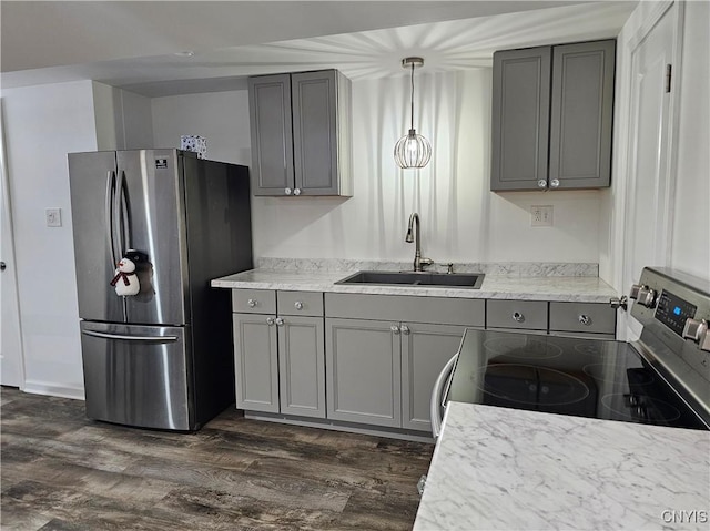 kitchen with dark wood-type flooring, stainless steel appliances, gray cabinetry, pendant lighting, and a sink