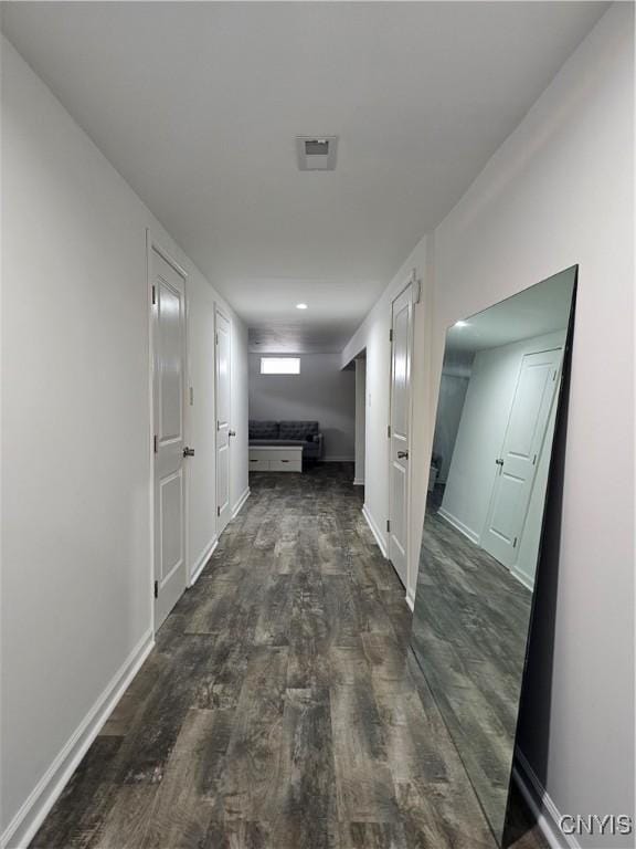 hallway with dark wood-style flooring and baseboards