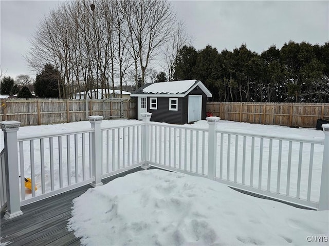 exterior space with a fenced backyard, a wooden deck, and an outbuilding