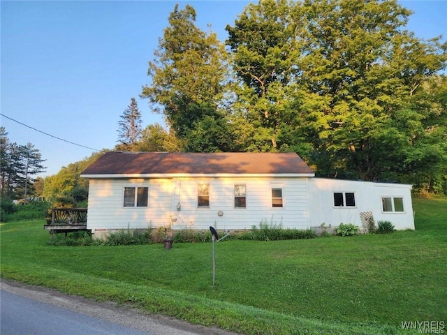 view of home's exterior with a yard and a deck