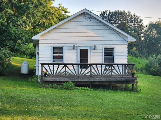 rear view of property with a lawn and a wooden deck