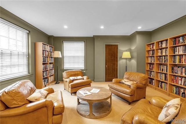 sitting room with ornamental molding, recessed lighting, and light colored carpet