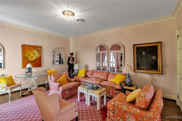 living room with ornamental molding, wood finished floors, visible vents, and baseboards