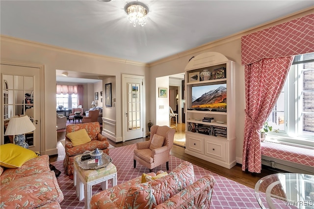 living area featuring a chandelier, crown molding, and wood finished floors