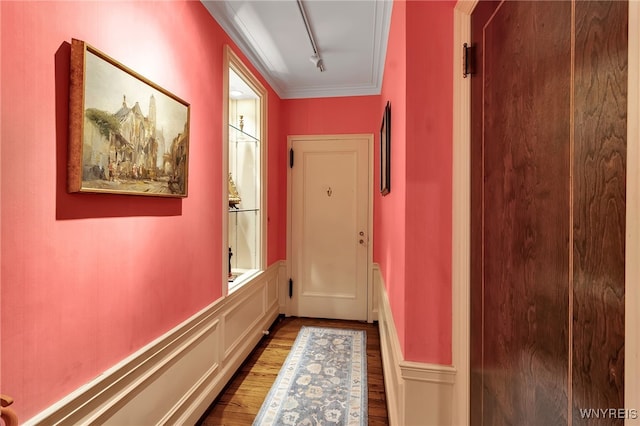 hallway with ornamental molding and wood finished floors