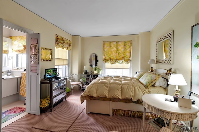 carpeted bedroom featuring multiple windows and connected bathroom