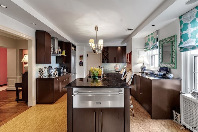 kitchen featuring a warming drawer, dark brown cabinets, and visible vents