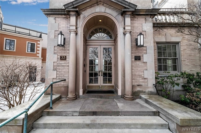 doorway to property with brick siding and french doors