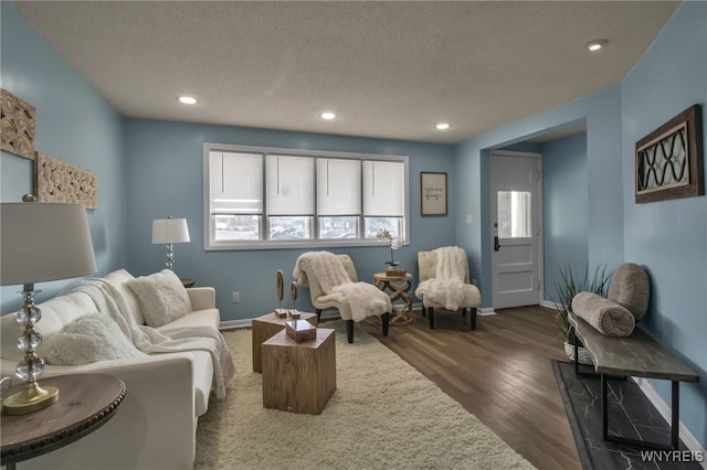 living area featuring a textured ceiling, wood finished floors, and recessed lighting