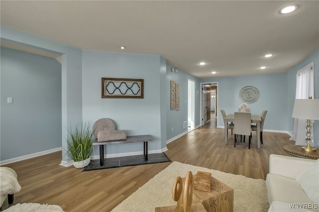 living area featuring recessed lighting, baseboards, and wood finished floors