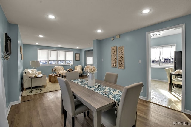 dining space with baseboards, wood finished floors, and recessed lighting