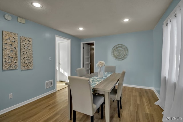 dining room with baseboards, visible vents, wood finished floors, and recessed lighting