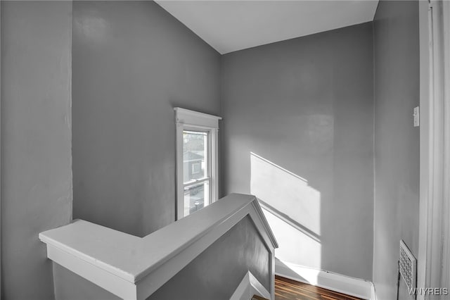 staircase with visible vents and wood finished floors