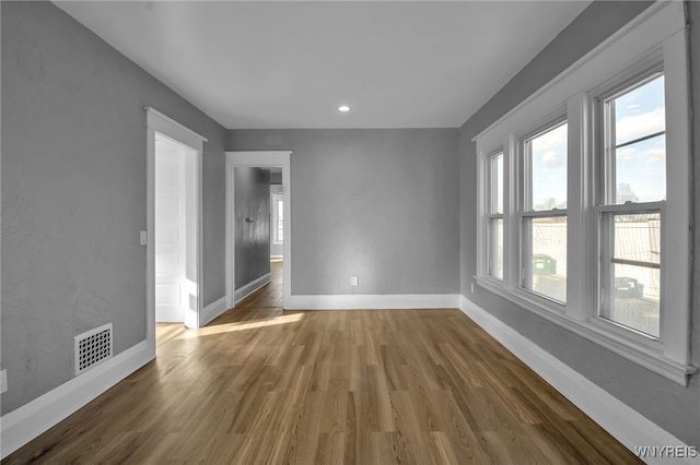 spare room featuring recessed lighting, visible vents, baseboards, and wood finished floors