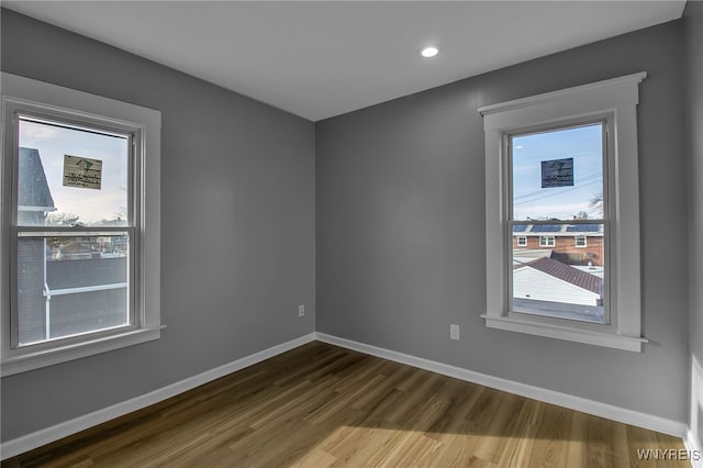 spare room featuring baseboards, dark wood finished floors, and recessed lighting