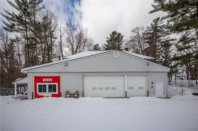 snow covered garage featuring a garage