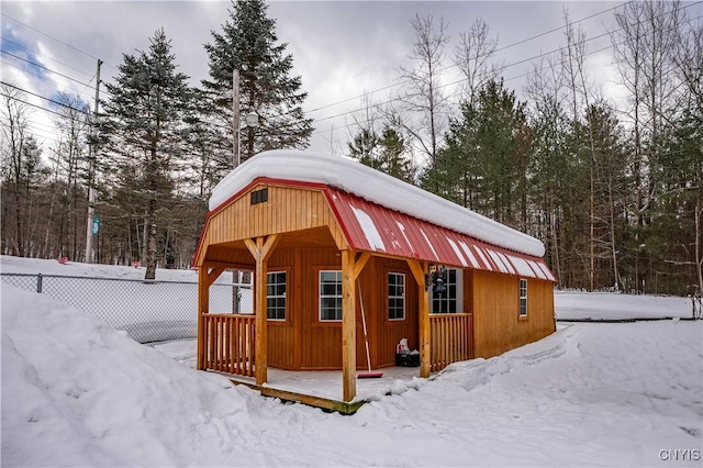 snow covered structure featuring fence