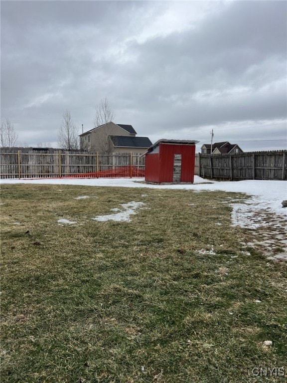 view of yard featuring a storage shed, an outbuilding, and a fenced backyard