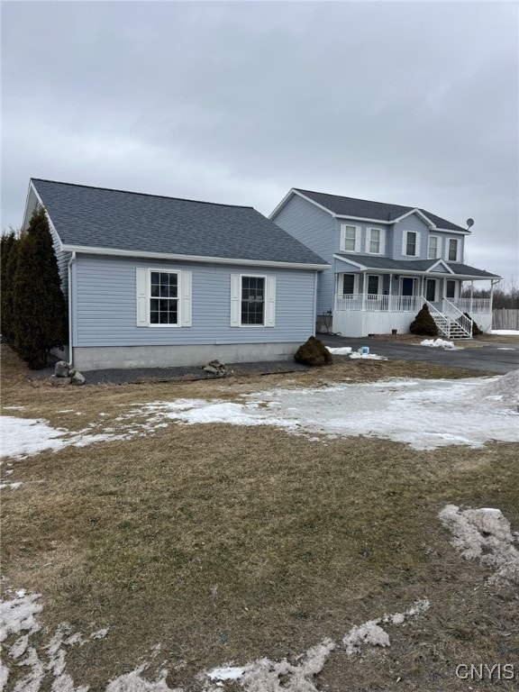 view of front of property featuring a porch and roof with shingles